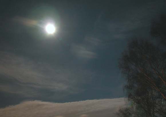 Vollmond und Wolken im Reflexlicht der Stadt